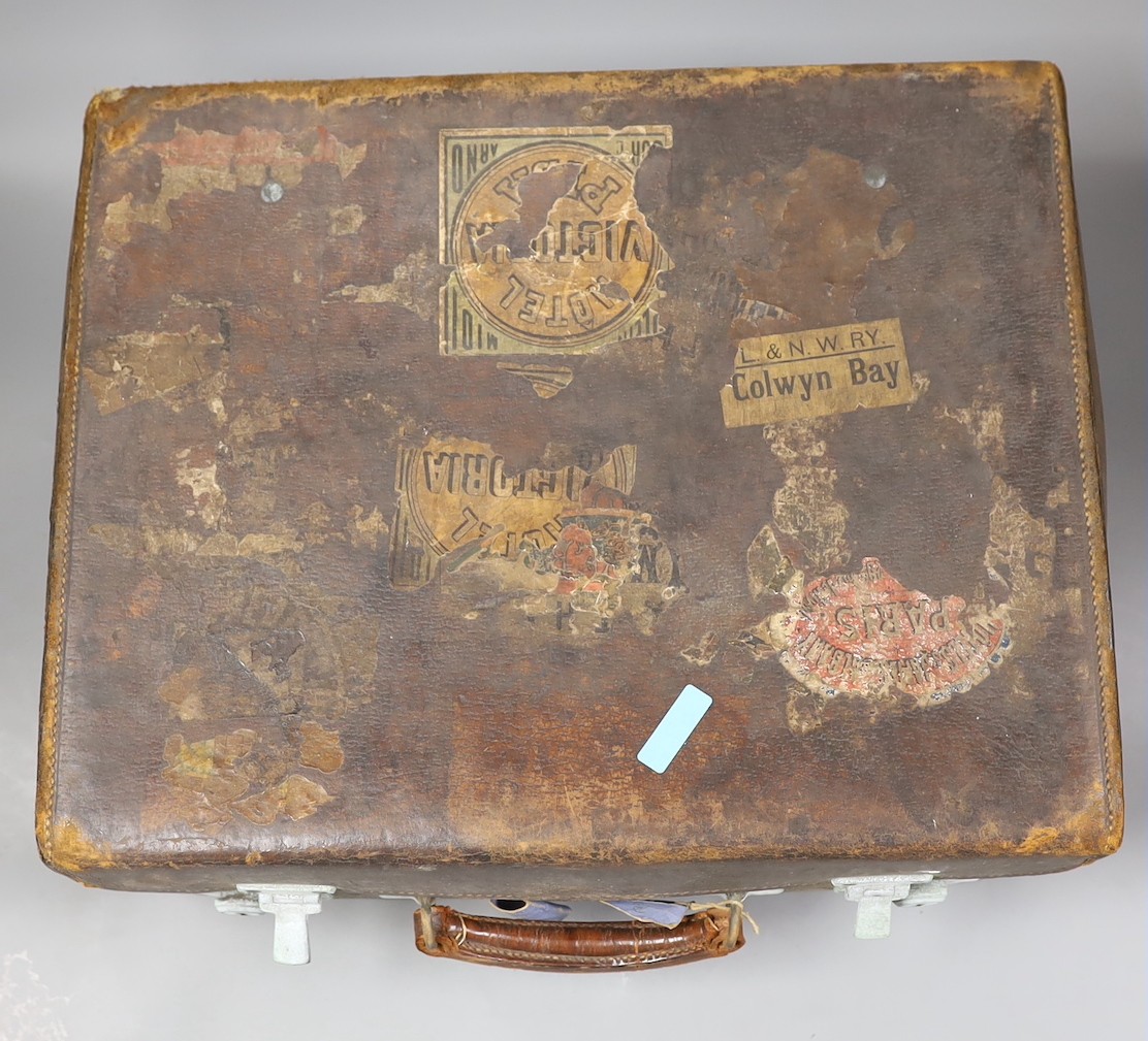 A late Victorian leather travelling vanity case containing five repousse silver topped glass toilet jars, 43.8cm.